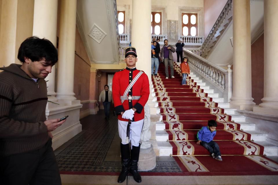 FILE - In this Aug. 10, 2013 file photo, a presidential guard officer provides security as people visit the government palace or "Palacio de Los Lopez" in Asuncion, Paraguay. The Public Works Ministry said Monday, May 12, 2014 that the west wing of the palace is infested with termites, but the main wooden structure is not endangered for now. The Lopez Palace is the seat of Paraguay's government and home and office to President Horacio Cartes. The neoclassic building dates back to 1857. (AP Photo/Jorge Saenz, File)