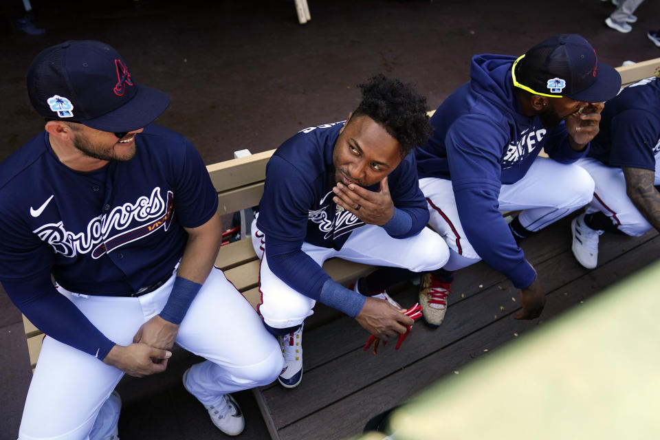 Atlanta Braves second baseman Ozzie Albies, center, sits in the dugout with teammates during a spring training baseball game against the Boston Red Sox on Saturday, Feb. 25, 2023, in North Port, Fla. (AP Photo/Brynn Anderson)