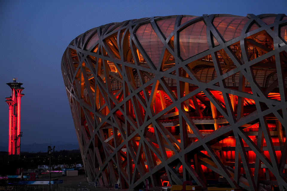 El Estadio Nacional y la Torre Olímpica iluminadas de rojo, el lunes 31 de enero de 2021, en Beijing. (AP Photo/Jae C. Hong)