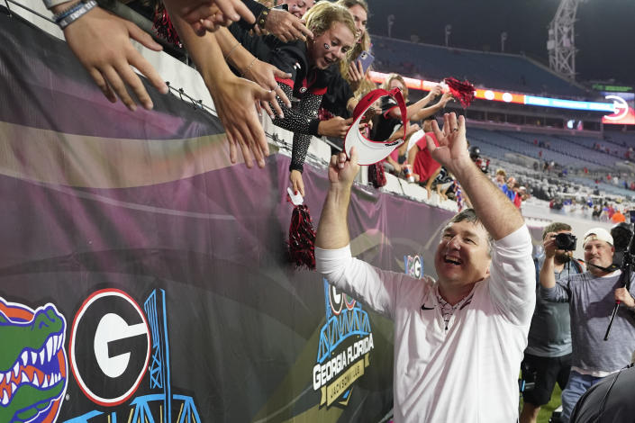 Georgia head coach Kirby Smart, right, high-fives fans after defeating Florida in an NCAA college football game, Saturday, Oct. 29, 2022, in Jacksonville, Fla. (AP Photo/John Raoux)