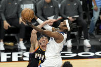 Minnesota Timberwolves forward Jaden McDaniels, right, drives past Phoenix Suns guard Devin Booker during the first half of Game 4 of an NBA basketball first-round playoff series, Sunday, April 28, 2024, in Phoenix. (AP Photo/Ross D. Franklin)
