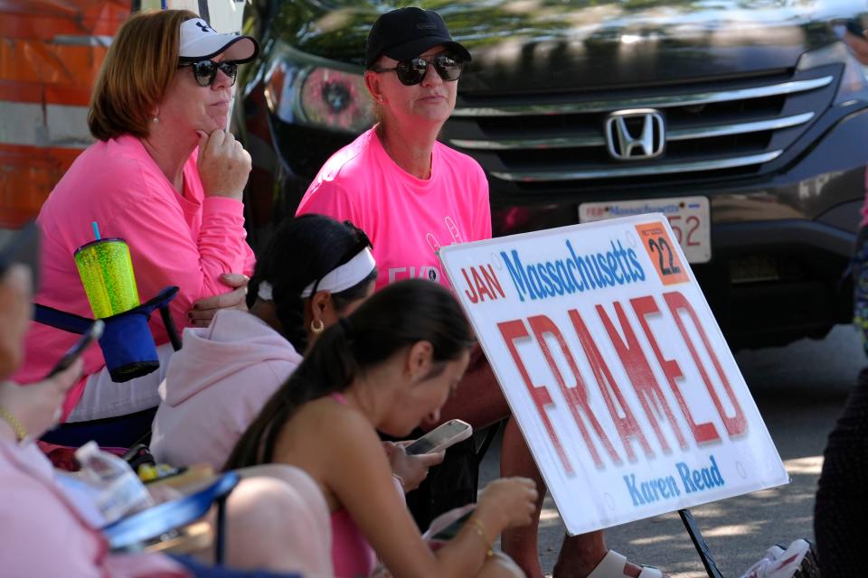 Lisa Hoffman, of Mansfield, Mass., right, displays a sign in support of Karen Read that features a likeness of a Massachusetts license plate, while seated a block away from Norfolk Superior Court, Tuesday, June 25, 2024, in Dedham, Mass. Karen Read is on trial, accused of killing her boyfriend Boston police Officer John O'Keefe, in 2022. (AP Photo/Steven Senne)