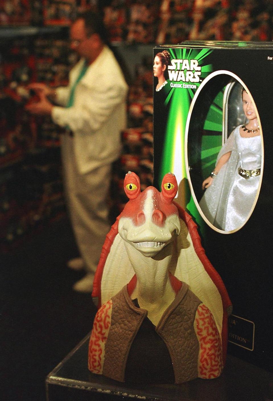 GARDEN CITY, :  A figure of the character called Jar Jar Binks (C) from the new Star Wars movie The Phantom Menace sits next to a figure of Princess Leia (R) from the original Star Wars trilogy in a display at FAO Schwartz 07 May 1999 in Garden City, NY. FAO Schwartz filled an entire room with toys from both the new movie as well as the original series when the new figures were released 03 May 1999 . AFP PHOTO/Matt CAMPBELL (Photo credit should read MATT CAMPBELL/AFP via Getty Images)