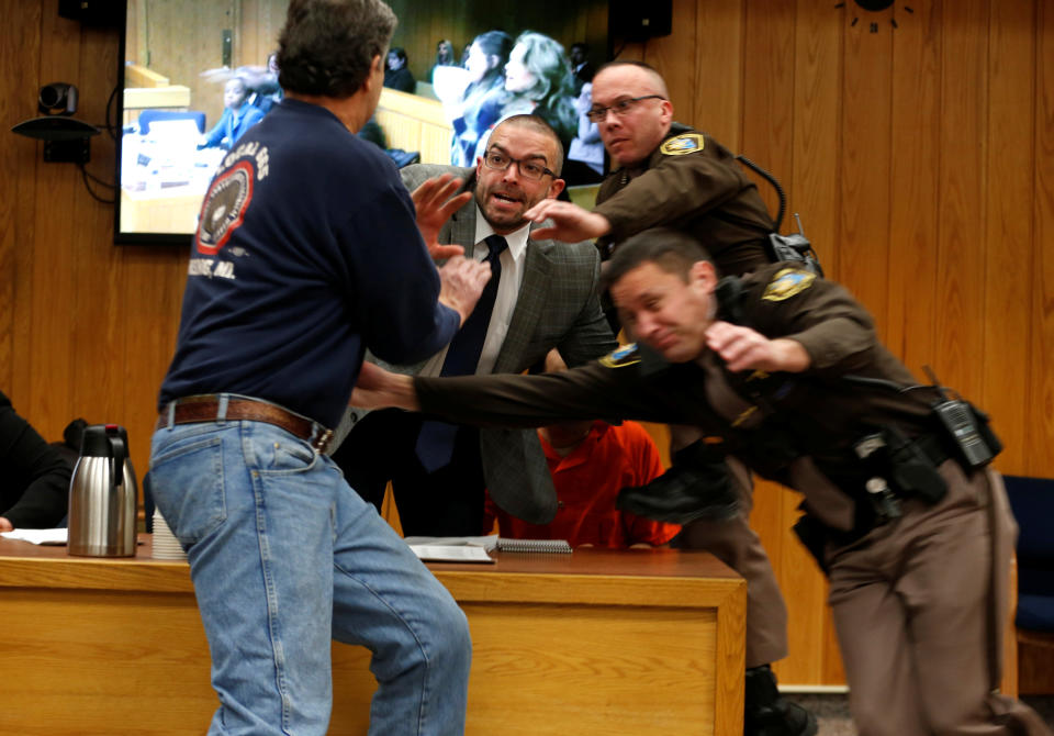 Randall Margraves (L) lunges at disgraced former USA Gymnastics team doctor Larry Nassar (wearing orange) during victim impact statements in a Michigan courtroom. (Reuters)