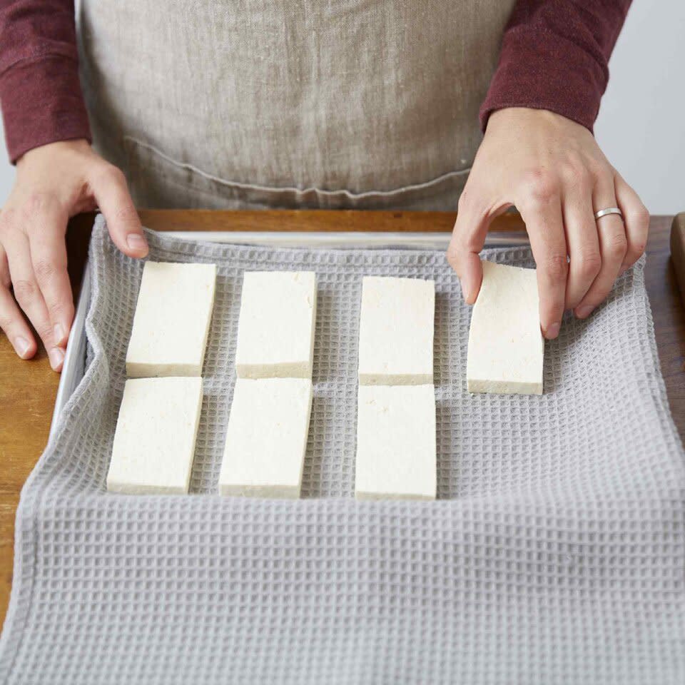 Placing tofu on a towel-lined sheet pan