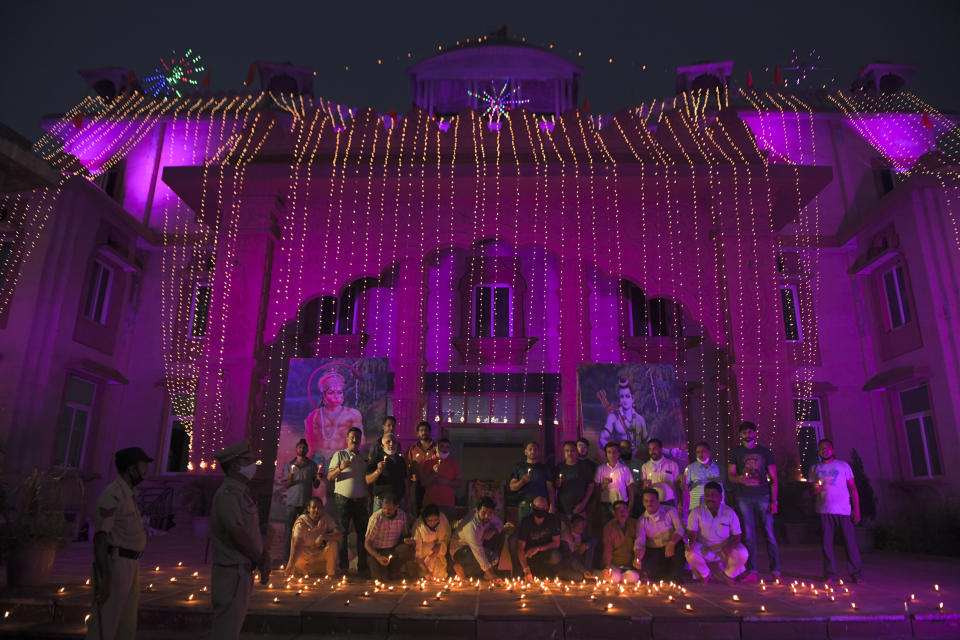 Hindu devotees gather while lighting earthen lamps on the banks of the River Sarayu on the eve before the groundbreaking ceremony of the proposed Ram Temple in Ayodhya on August 4, 2020. - India's Prime Minister Narendra Modi will lay the foundation stone for a grand Hindu temple in a highly anticipated ceremony at a holy site that was bitterly contested by Muslims, officials said. (Photo by SANJAY KANOJIA / AFP)