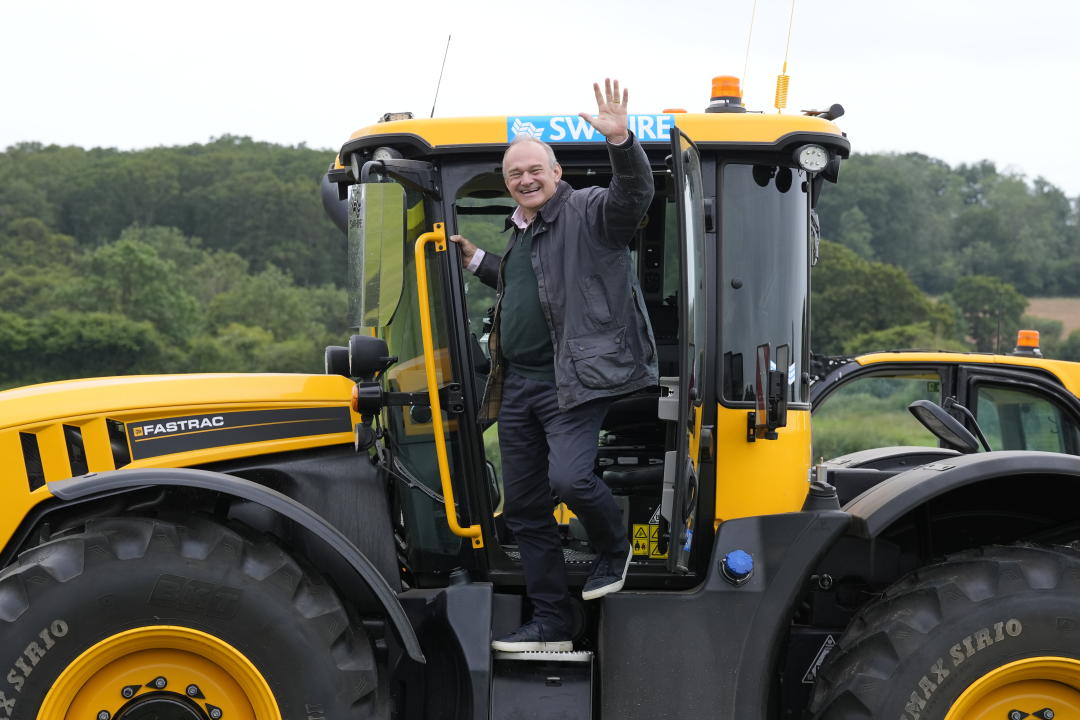 Sir Ed Davey waves in a tractor during his visit to Owl Lodge in Lacock, Wiltshire, this morning. (PA)