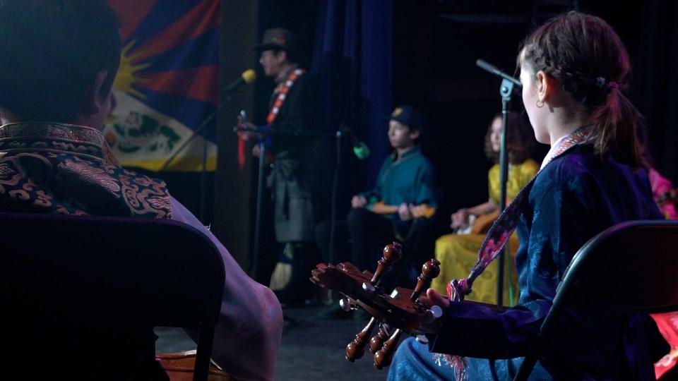 An ensemble of children perform music with a plucked string instrument called the dramyin at the 18th Tibet Festival on Nov. 19, 2022 at Burlington's O.N.E. Community Center.