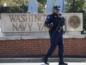 A police officer stands at the main gate of the Washington Navy Yard in Washington, September 17, 2013. Stunned Washington authorities questioned on Tuesday how a U.S. military veteran with a record of brushes with the law could get clearance to enter a Navy Base where he killed 12 people before police shot him dead. (REUTERS/Jason Reed)