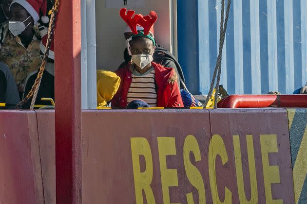 A child wearing a christmas hat looks on as she arrives aboard the rescue vessel Sea-Eye 4 in the port of Pozzallo, southern Sicily, on December 24, 2021. - German migrant rescue charity Sea-Eye said on December 17, 2021 one of its boats had picked over 200 migrants in the Mediterranean and accused Malta of failing to respond to distress calls. The Sea-Eye 4 rescue ship has picked up the migrants in four rescue missions since December 16 