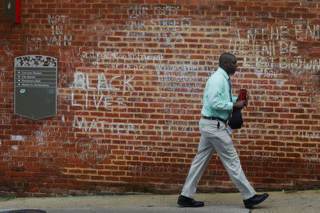 A man walks past tributes written at the site where Heather Heyer was killed during the 2017 white-nationalist rally in Charlottesville, Virginia, U.S., August 1, 2018. REUTERS/Brian Snyder