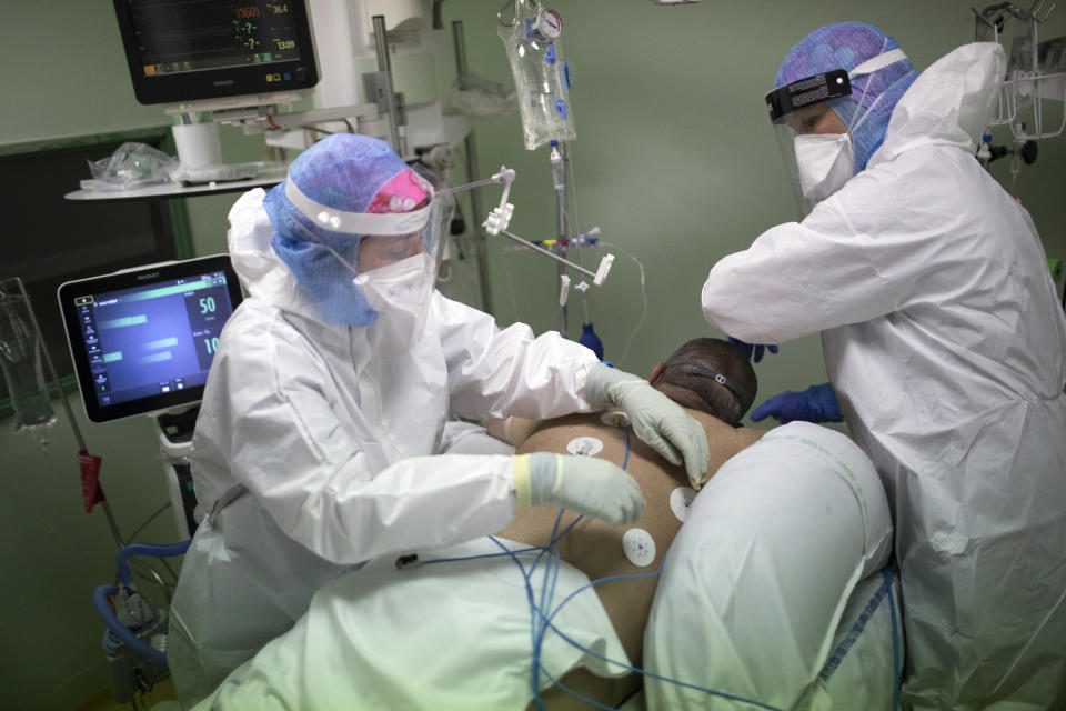 A medical crew treat a COVID-19 patient in the intensive care unit at the Joseph Imbert Hospital Center in Arles, southern France, Wednesday, Oct. 28, 2020. Many French doctors are urging a new nationwide lockdown, noting that 58% of the country's intensive care units are now occupied by COVID patients and medical staff are under increasing strain. (AP Photo/Daniel Cole)