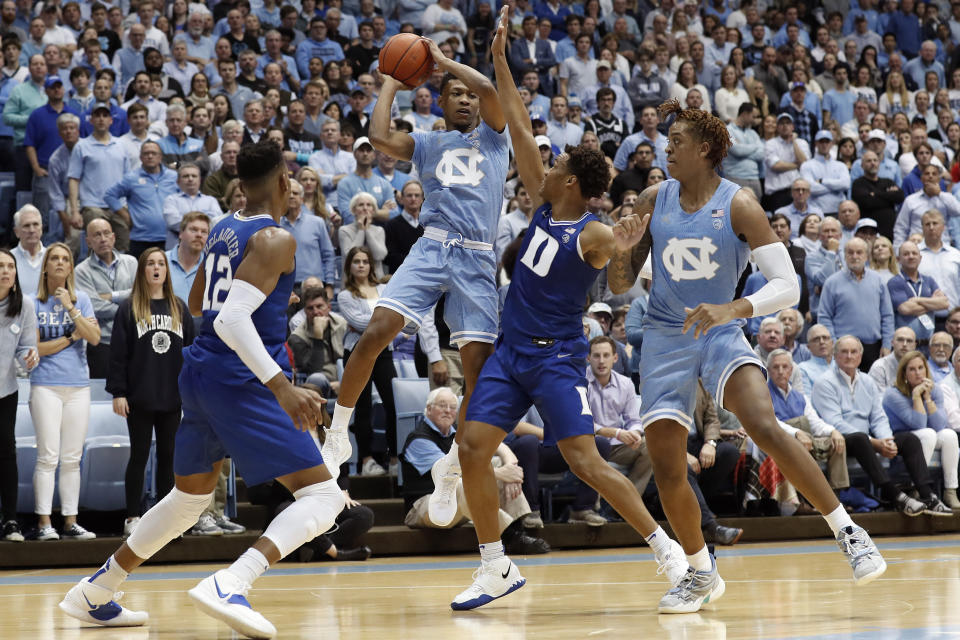 North Carolina guard Christian Keeling looks to pass while forward Armando Bacot, right, defends against Duke forward Javin DeLaurier (12) and forward Wendell Moore Jr. during the first half of an NCAA college basketball game in Chapel Hill, N.C., Saturday, Feb. 8, 2020. (AP Photo/Gerry Broome)