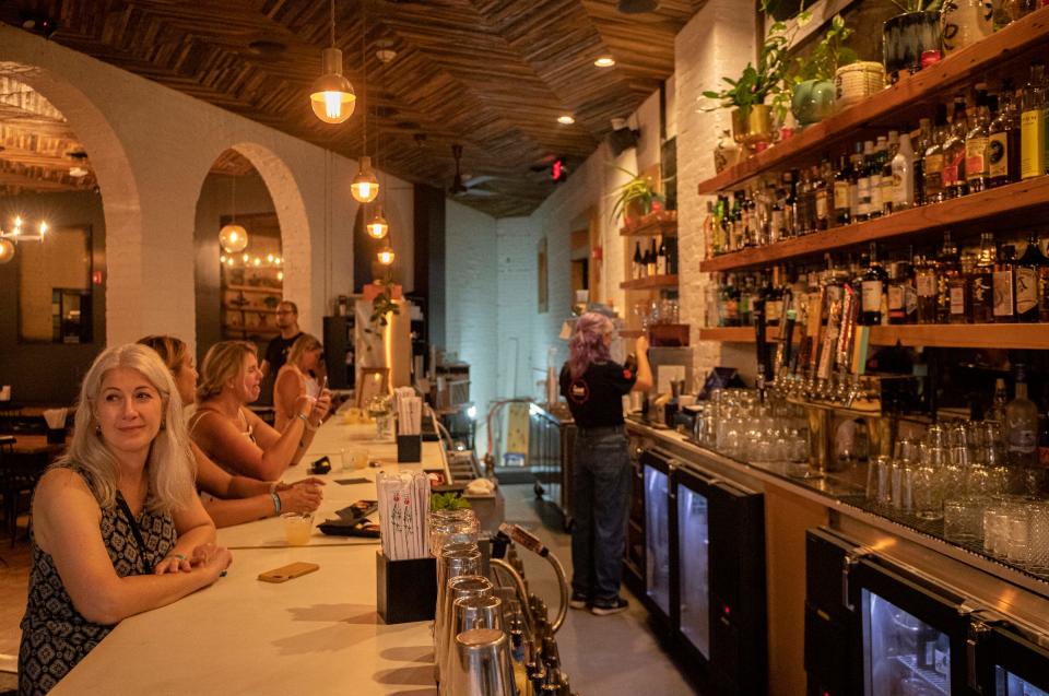 Gina Randall, of Rochester Hills, tries food served at Ima, Corktown, one of the 23 restaurants people tried throughout downtown area as part of the EAT Detroit restaurant experience in Detroit on Aug. 3, 2022.