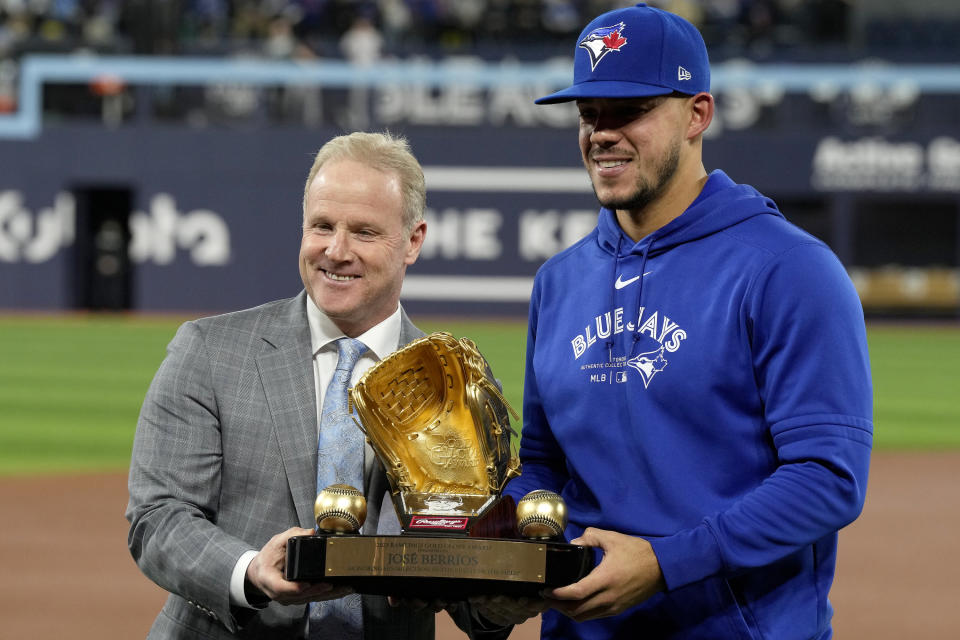 Toronto Blue Jays' Jose Berrios, right, receives his golden glove award from Steve Cohen, left, director of pro baseball services at Rawlings, during a ceremony prior to a baseball game against the Colorado Rockies in Toronto, Friday, April 12, 2024. (Frank Gunn/The Canadian Press via AP)