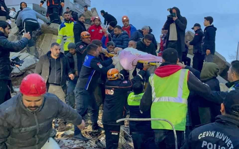 A child is carried out of the rubble of a collapsed building in Adana, in Turkey, on Monday morning - Anadolu Agency