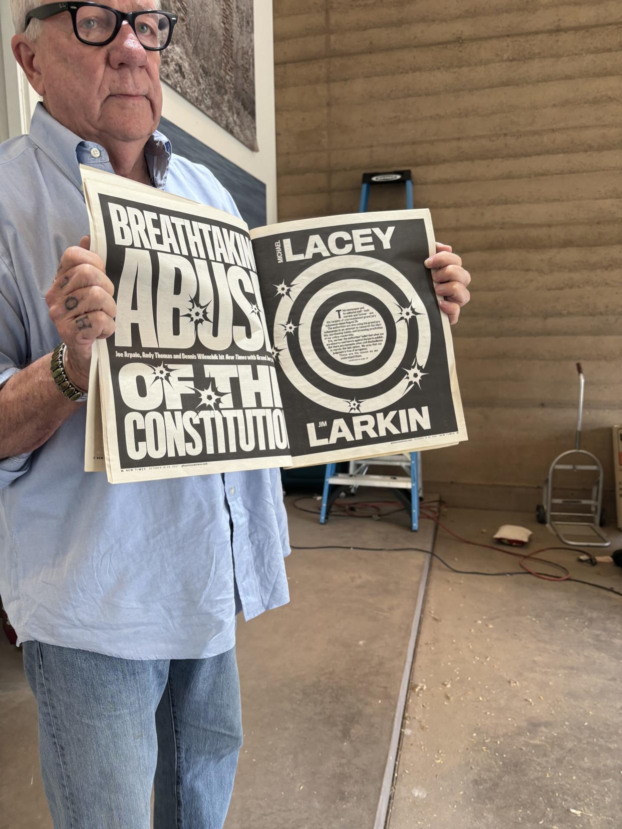 Lacey holds up a copy of a Phoenix New Times article about he and Larkin's prosecution by former Maricopa County Sheriff Joe Arpaio.