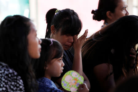 A woman cries while attending an outdoor church service in the earthquake damaged area of Jono Oge village, in Sigi district, south of Palu, Central Sulawesi, Indonesia October 7, 2018. REUTERS/Darren Whiteside