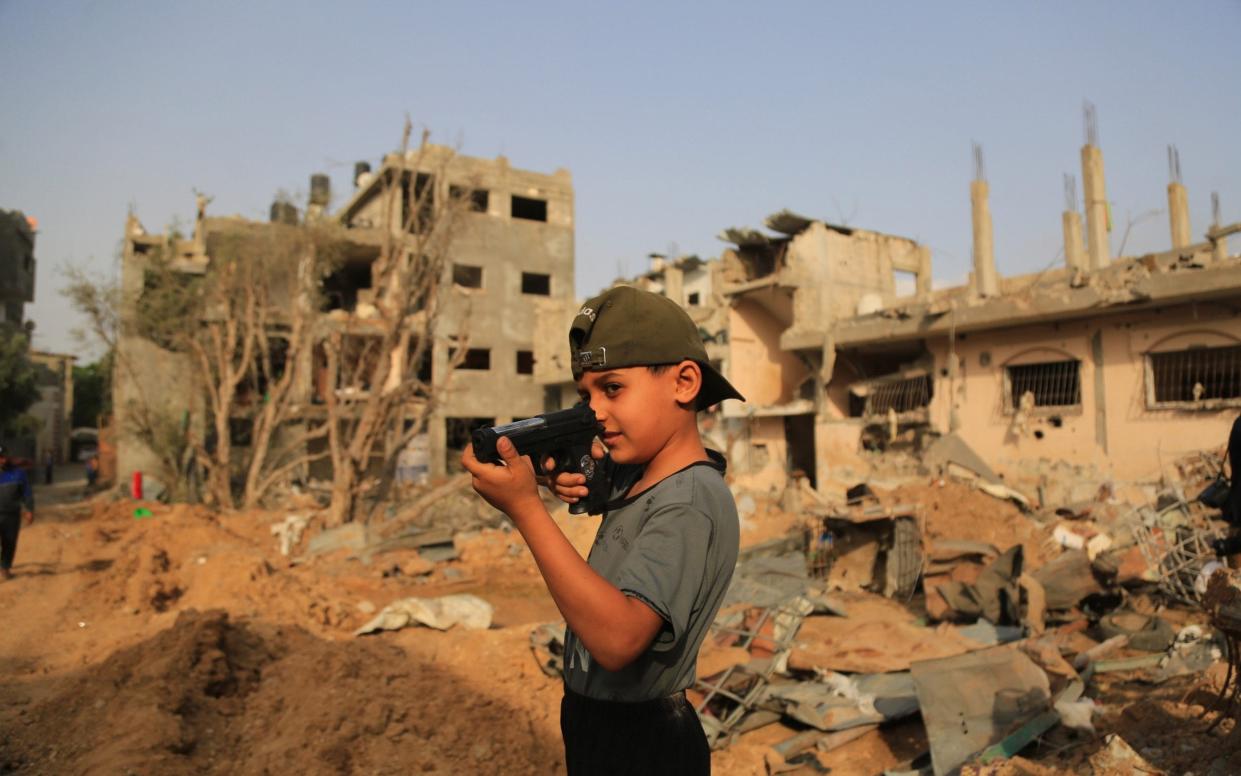 Boy plays with toy gun. Palestinians at Bait Hanoun city northern the Gaza Strip - MEGA