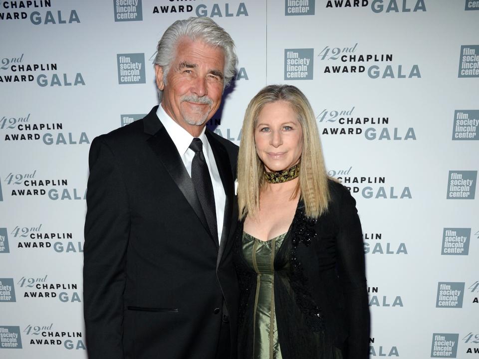 James Brolin, in a black suit, poses with Barbra Streisand, in a green gown and black jacket.