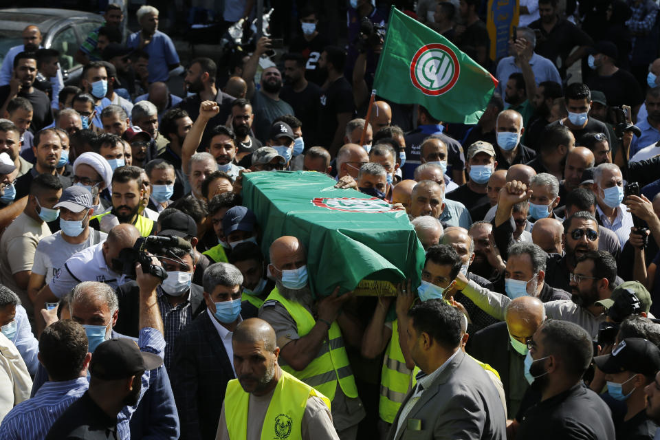 Supporters of the Shiite Amal group carry the coffin of Hassan Jamil Nehmeh, who was killed during yesterday clashes, during his funeral processions in the southern Beirut suburb of Dahiyeh, Lebanon, Friday, Oct. 15, 2021. The government called for a day of mourning following the armed clashes, in which gunmen used automatic weapons and rocket-propelled grenades on the streets of the capital, echoing the nation’s darkest era of the 1975-90 civil war. (AP Photo/Bilal Hussein)