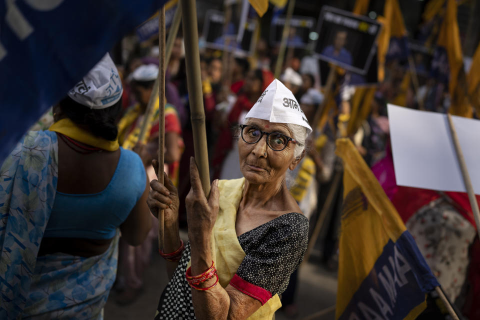 An elderly supporter of Aam Admi Party holds a party flag during a roadshow by Sunita Kejriwal, wife of the jailed Party leader and Delhi Chief Minister Arvind Kejriwal, ahead of the third round of polling in the six-week long national election in New Delhi, India, Saturday, April 27, 2024. (AP Photo/Altaf Qadri)