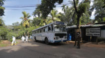 Sri Lankan crime investigators, in protective suits, leave the Mahara prison complex after their inspection following an overnight unrest in Mahara, outskirts of Colombo, Sri Lanka, Monday, Nov. 30, 2020. Sri Lankan officials say six inmates were killed and 35 others were injured when guards opened fire to control a riot at a prison on the outskirts of the capital. Two guards were critically injured. Pandemic-related unrest has been growing in Sri Lanka's overcrowded prisons. (AP Photo/Eranga Jayawardena)