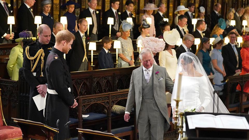 Prince Harry looks at his bride, Meghan Markle, as she arrives accompanied by Prince Charles, Prince of Wales during their wedding