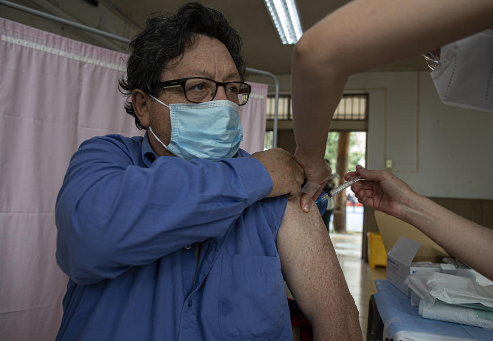 Un hombre es inoculado con una dosis de la vacuna Sinovac para el COVID-19 en un centro de vacunación en la escuela pública José Toribio Medina en Santiago, Chile, el martes 16 de marzo de 2021. (AP Foto/Esteban Félix)