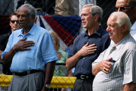 FILE PHOTO: U.S. President George W. Bush (C) stands for the National Anthem with baseball Hall of Famers Frank Robinson (L) and Tommy Lasorda before a tee ball game on the South Lawn of the White House in Washington July 15, 2007. REUTERS/Jonathan Ernst/File Photo