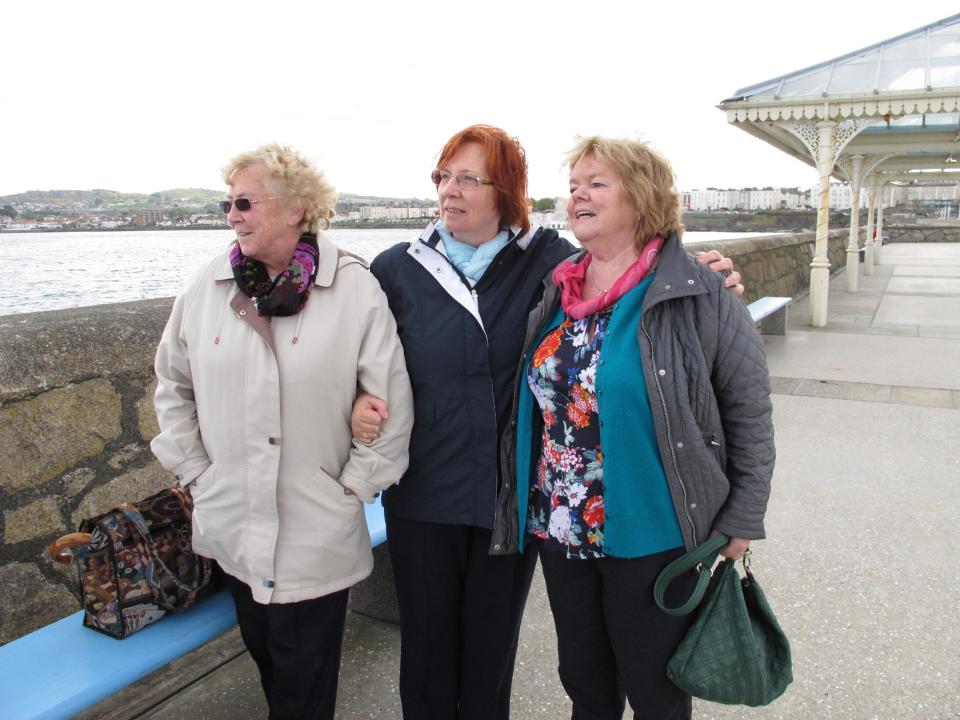 In this May 13, 2013 photo, Marie Theresa Gill, center, poses with her friends Kathleen Greenhough, right, and Mary Murray at the pier in Dun Laoghaire in Dublin Co., after a wreath-laying ceremony to honor the so-called "Forgotten Irish" _the thousands of young Irish who emigrated to Britain during the 1950s and 1960s. Gill and Greenhough were among those emigrants. They returned as part of The Gathering, an effort by Ireland to bring its emigrants and their descendants home to honor them and their heritage. (AP Photo/Helen O'Neill)