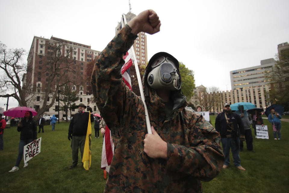 A protester raises his fist during a rally against Michigan’s coronavirus stay-at-home order at the State Capitol in Lansing, Mich., Thursday, May 14, 2020. (AP Photo/Paul Sancya)