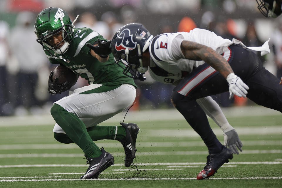 New York Jets wide receiver Garrett Wilson (17) tries to avoid Houston Texans safety Jalen Pitre (5) during the second half of an NFL football game, Sunday, Dec. 10, 2023, in East Rutherford, N.J. (AP Photo/Adam Hunger)