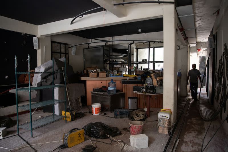 A worker walks inside the damaged "Tenno" bar, in the aftermath of a massive explosion at the port area, in Beirut