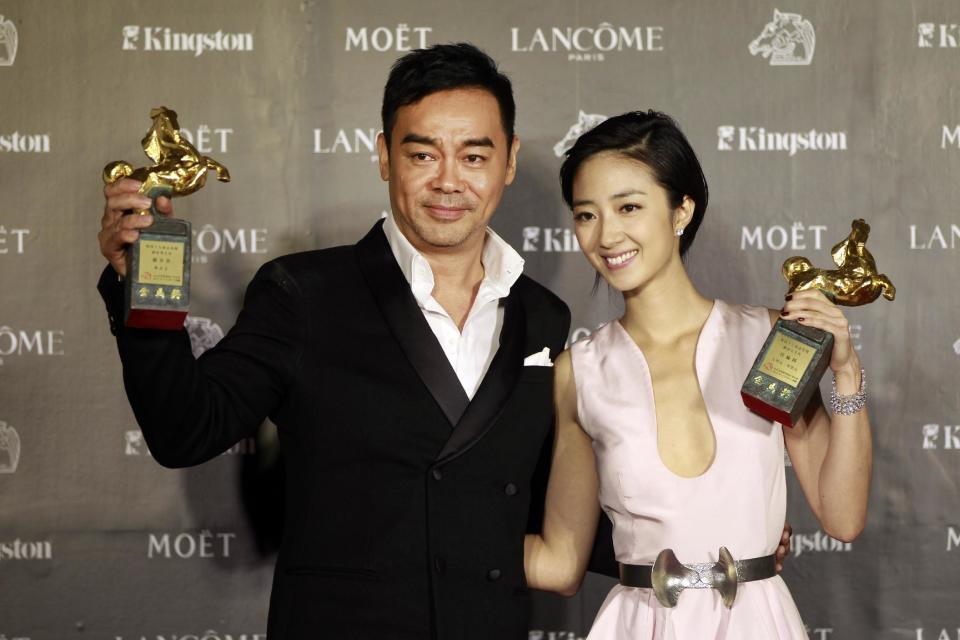 Taiwanese actress Gwei Lun-Mei and Hong Kong actor Lau ChingWan hold their awards for Best Actress and Best Actor for the film "GF * BF" and "Life Without Principle" at the 49th Golden Horse Awards at the Luodong Cultural Working House in Yilan County, Taiwan, Saturday, Nov. 24, 2012. The Golden Horse awards are the Chinese-language film industry's biggest annual events. (AP Photo/Wally Santana)