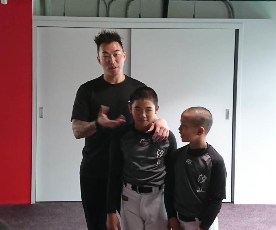 郭泓志（左）親切指導少棒球員正確的健身觀念。（廖德修攝）