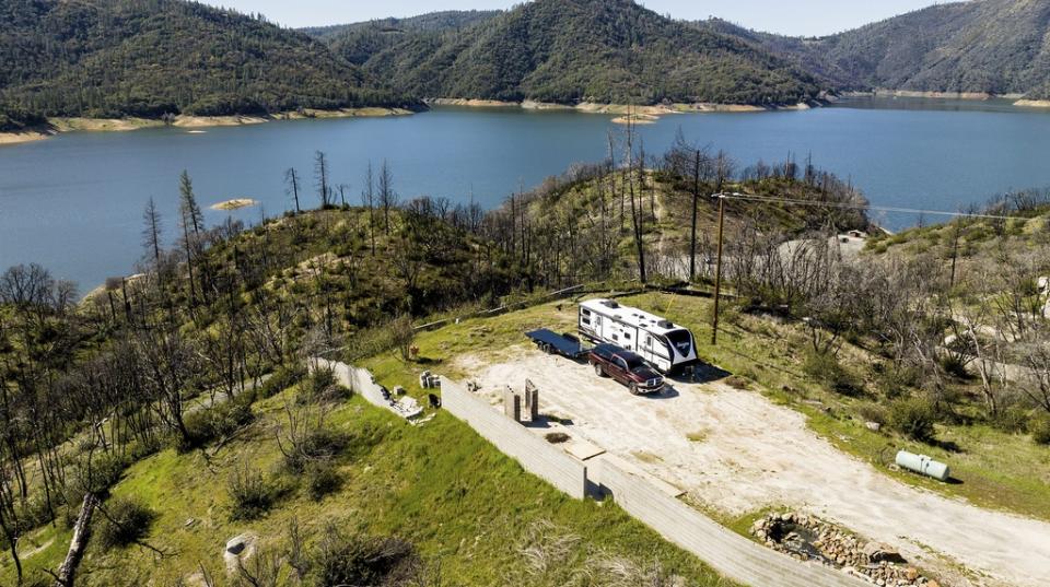 A trailer stands at a property scorched in the 2020 North Complex Fire above Lake Oroville on Sunday, March 26, 2023, in Butte County, Calif. Months of winter storms have replenished California’s key reservoirs after three years of punishing drought. (AP Photo/Noah Berger)