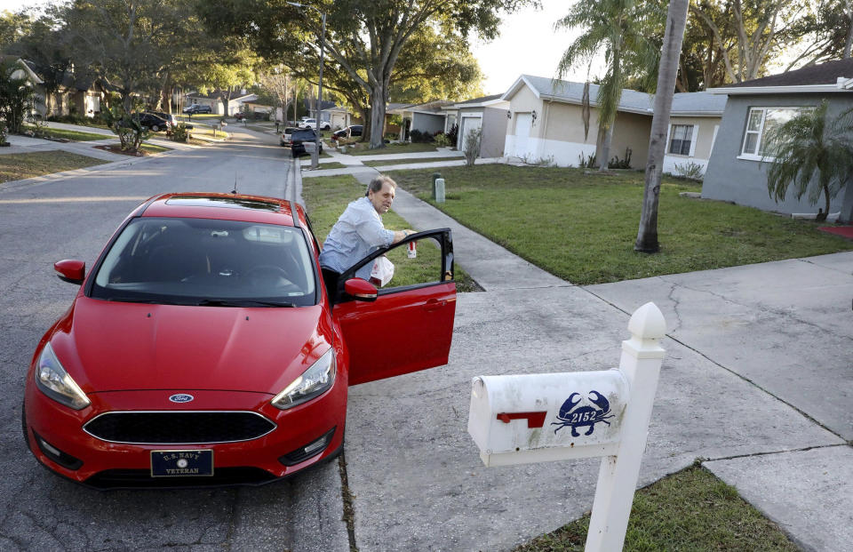 File - Nevin Overmiller, 78, walks a KFC food delivery to a customer's door while delivering for Uber Eats, Wednesday, Jan 5, 2021, in Palm Harbor, Fla. Attacks which occurred in Florida last month sent ripples of fear among some app-based drivers, who have long demanded better protection from companies whose safety policies they say are bettered geared toward customers than workers. (Douglas R. Clifford/Tampa Bay Times via AP, File)