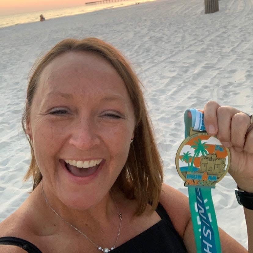 DeLeslyn Sullivan with an Ironman finisher's medal. By age 46, she had spent more than a decade pushing herself to do first runs, then marathons.