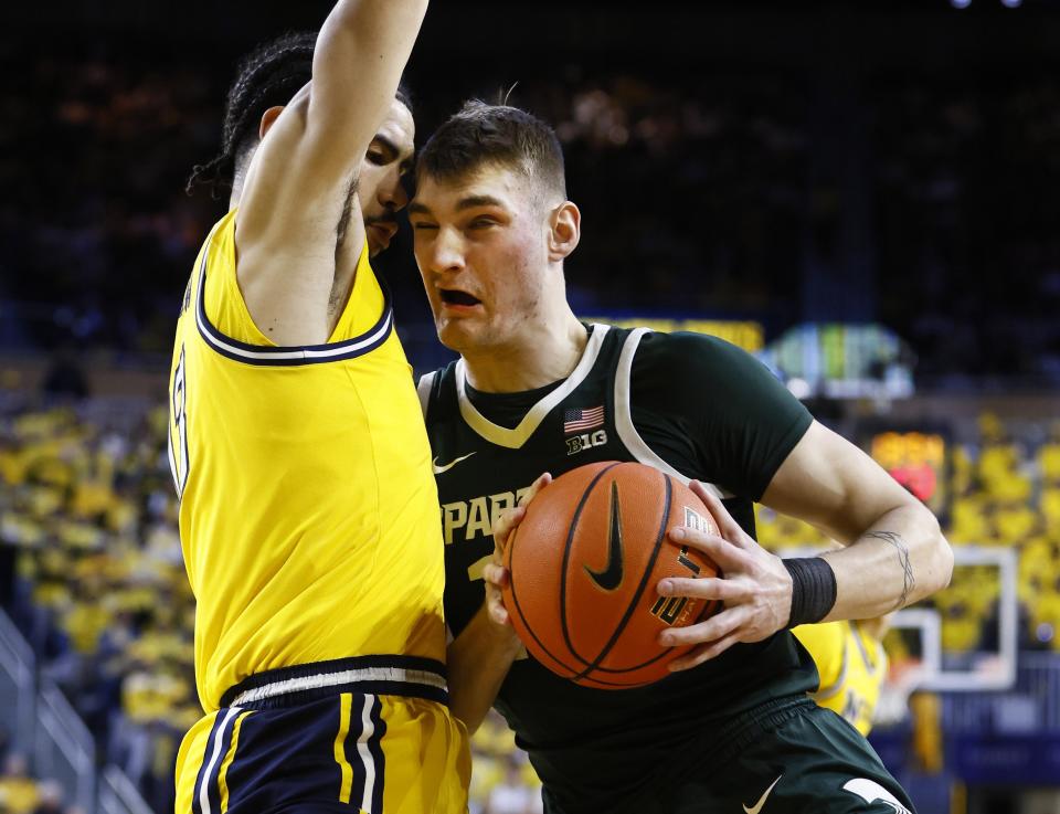 Michigan State center Carson Cooper, right, collides with Michigan forward Olivier Nkamhoua while going to the basket during the first half of an NCAA college basketball game Saturday, Feb. 17, 2024, in Ann Arbor, Mich. (AP Photo/Duane Burleson)