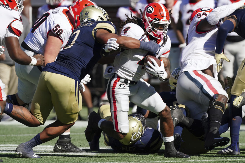Georgia running back James Cook (4) is stopped by Georgia Tech defensive lineman Djimon Brooks (0) after a short run in the first half of an NCAA college football game Saturday, Nov. 27, 2021, in Atlanta. (AP Photo/John Bazemore)