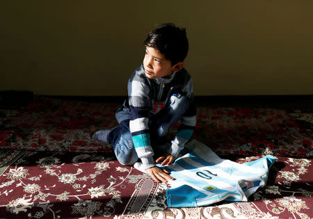 Murtaza Ahmadi, 7, an Afghan Lionel Messi fan, collects his T-shirt signed by Barcelona star Lionel Messi at his house in Kabul, Afghanistan December 8, 2018. REUTERS/Mohammad Ismail