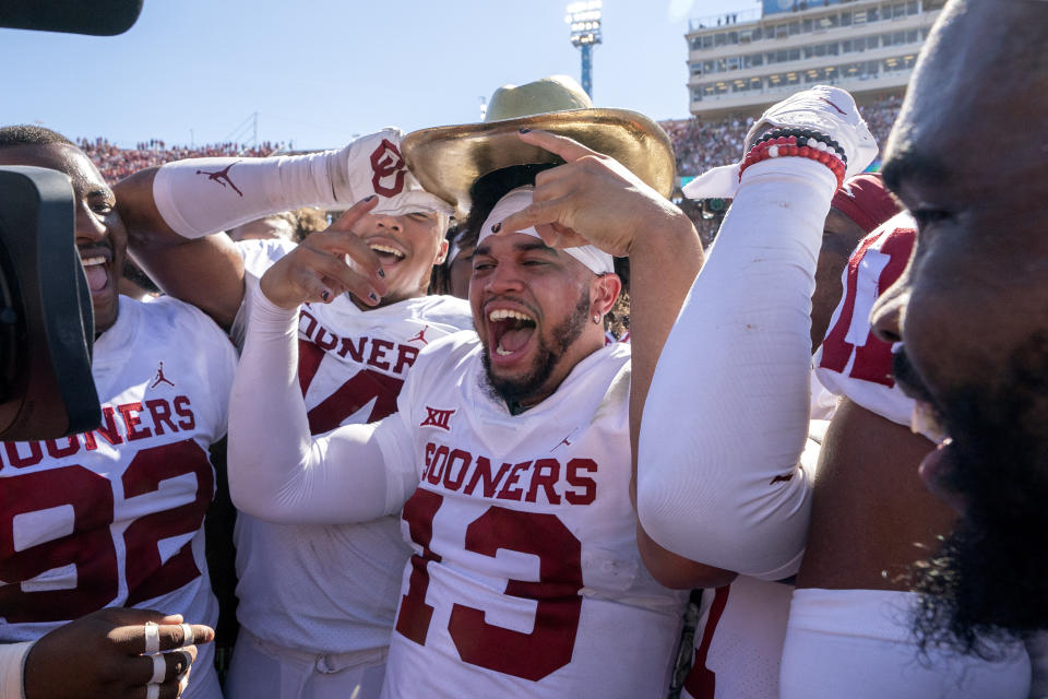 Oklahoma quarterback Caleb Williams (13) puts on the Golden Hat after coming off the bench to lead Oklahoma to a 54-48 win over Texas in an NCAA college football game at the Cotton Bowl, Saturday, Oct. 9, 2021, in Dallas. (AP Photo/Jeffrey McWhorter)