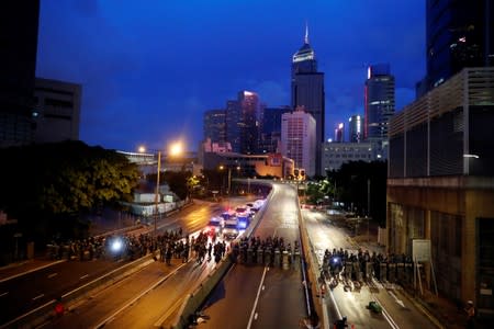 Riot police stand guard before they disperse anti-extradition bill protesters during a march in Hong Kong