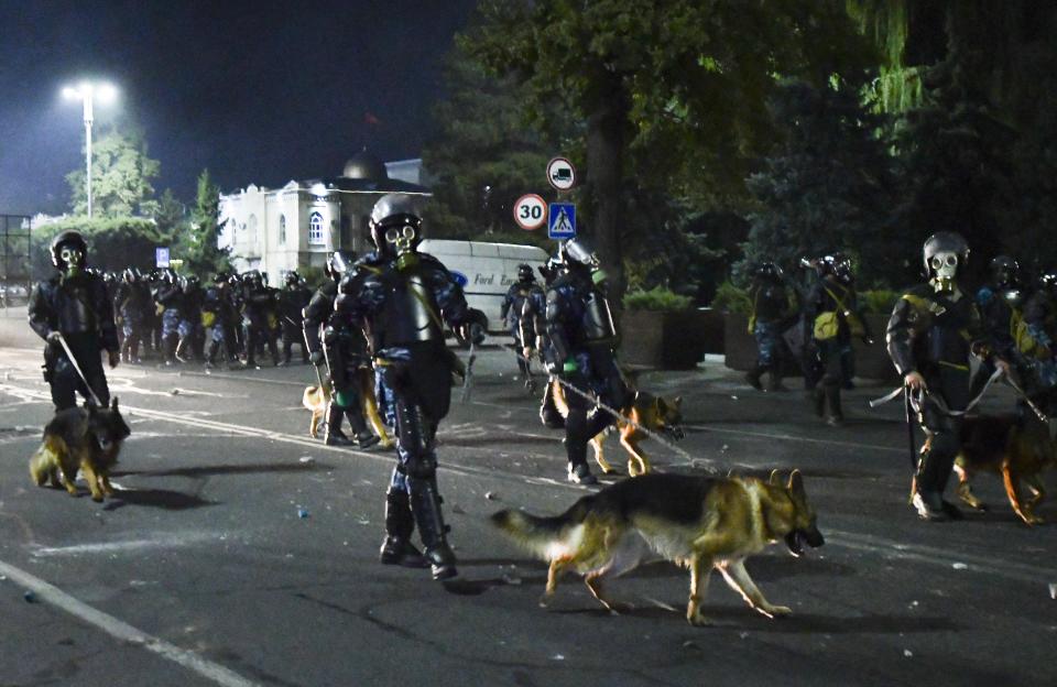 Riot police disperse protesters during a rally against the results of a parliamentary vote in Bishkek, Kyrgyzstan, Monday, Oct. 5, 2020. Large crowds of people have gathered in the center of Kyrgyzstan's capital to protest against the results of a parliamentary election, early results of which gave the majority of seats to two parties with ties to the ruling elites amid allegations of vote buying. (AP Photo/Vladimir Voronin)