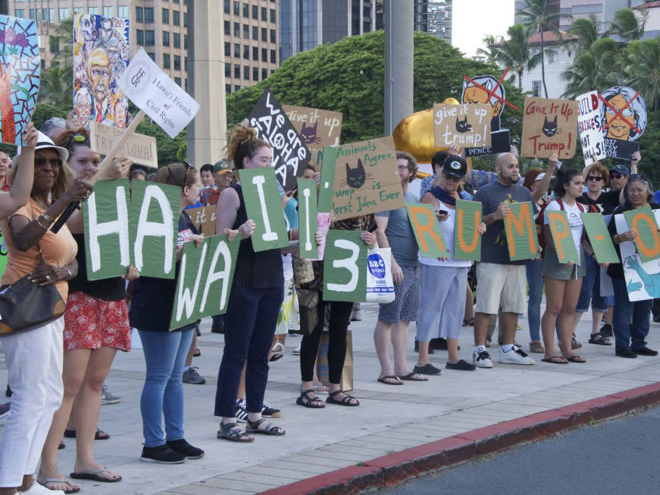 Protesters holding signs line up on Beretania Street during President Donald Trump's visit to Honolulu: AP