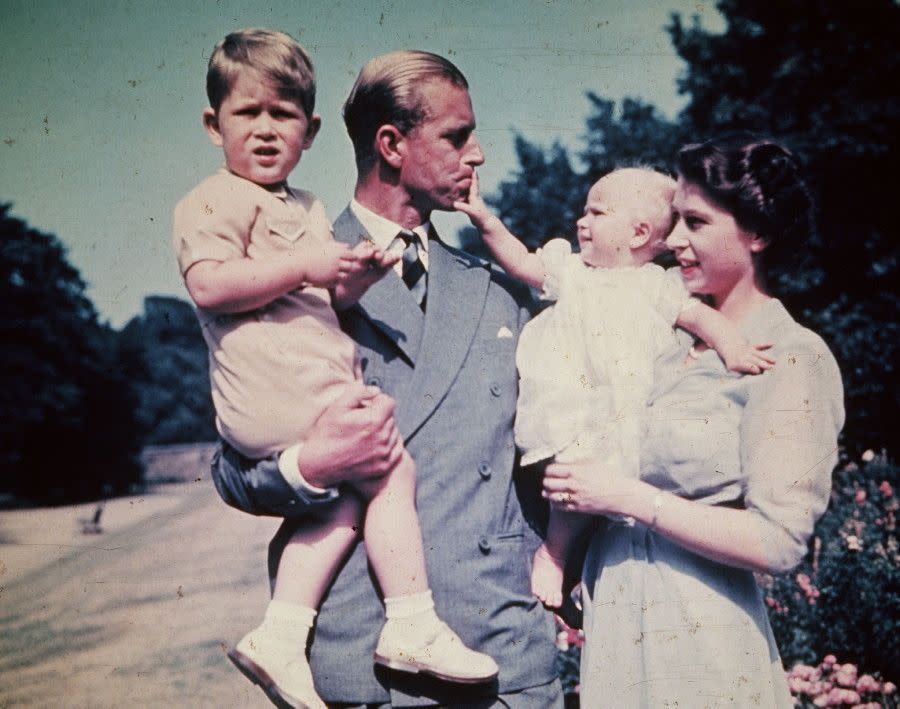 Everyone smile! Elizabeth holds her young daughter, Princess Anne, while her husband Philip poses with the couple's son, Charles, during a 1951 family outing.