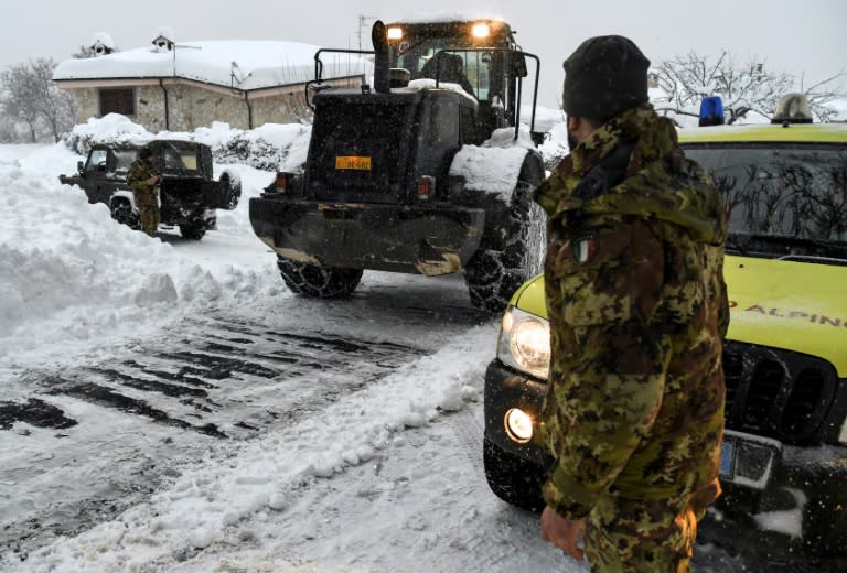 An Italian soldier takes part in an operation to clear snow from a street in Arigno, near Montereale, after fresh earthquakes on January 18, 2017