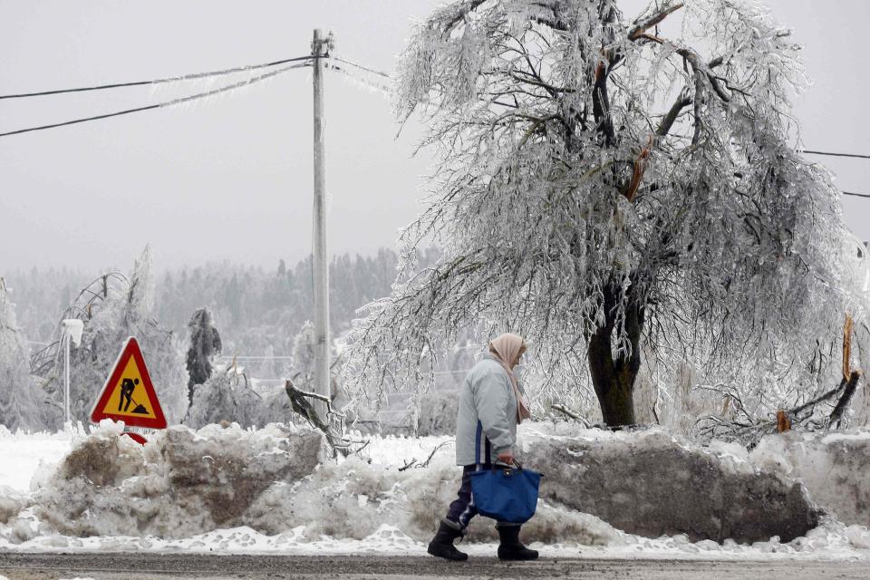 Esta mujer caminó junto a los árboles cubiertos de hielo y la nieve acumulada. REUTERS/Srdjan Zivulovic