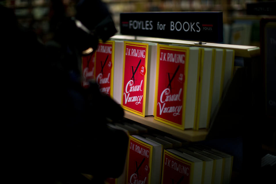 A light from a video camera shines on copies of the "The Casual Vacancy" by author J.K. Rowling displayed on shelves at a book store in London, Thursday, Sept. 27, 2012. British bookshops are opening their doors early as Harry Potter author J.K. Rowling launches her long anticipated first book for adults. Publishers have tried to keep details of the book under wraps ahead of its launch Thursday, but "The Casual Vacancy" has gotten early buzz about references to sex and drugs that might be a tad mature for the youngest "Potter" fans. (AP Photo/Matt Dunham)